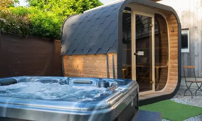 a hot tub in front of a house at Ferienhaus Kluser in Oberriet
