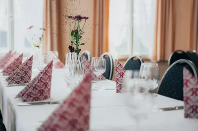 a table with red napkins and wine glasses on it at Hotel Krone Gais in Gais