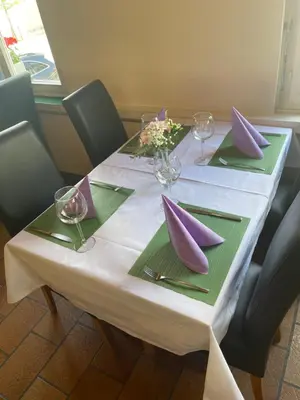 a table with purple and green napkins and wine glasses at Hotel Ochsen in Sankt Margrethen