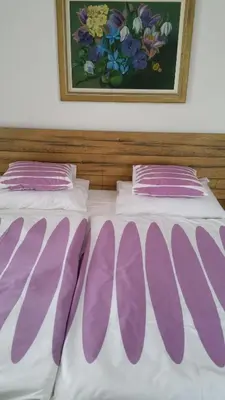 a bed with purple and white pillows on it at Hotel Ochsen in Sankt Margrethen