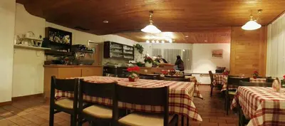 a restaurant with tables and chairs and a kitchen at Hotel Ochsen in Sankt Margrethen
