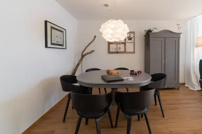 a dining room table with chairs and a laptop on it at Panorama Blick in Unterwasser