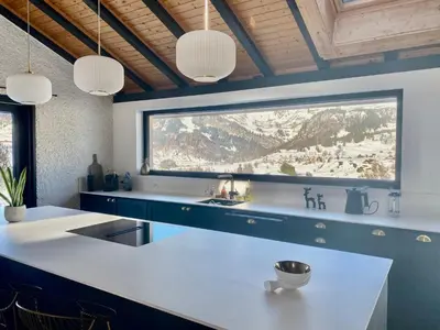 a kitchen with blue cabinets and a large window at Ski-InOut 4BR Alpen Chalet, Views & Fire in Alt Sankt Johann