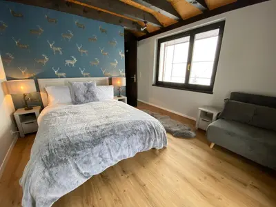 a bedroom with a large bed and a couch at Ski-InOut 4BR Alpen Chalet, Views & Fire in Alt Sankt Johann