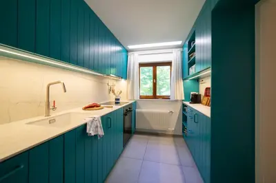 a green kitchen with a tub and a sink at Etienne in Wildhaus