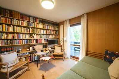 a room with a library with bookshelves and a tv at Etienne in Wildhaus