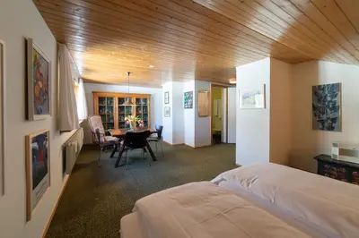 a bedroom with a bed and a dining room at Etienne in Wildhaus
