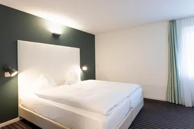 a bedroom with a large white bed in a room at Self Check-In Hotel David 22 in St. Gallen