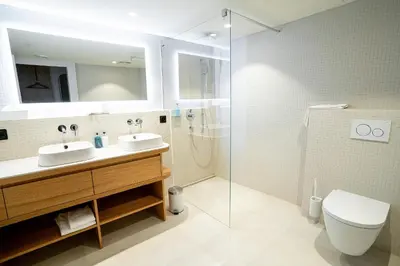 a bathroom with two sinks and a shower at Hotel Heiden - Wellness am Bodensee in Heiden