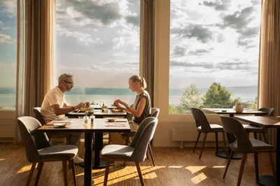 a man and woman sitting at a table in a restaurant at Hotel Heiden - Wellness am Bodensee in Heiden