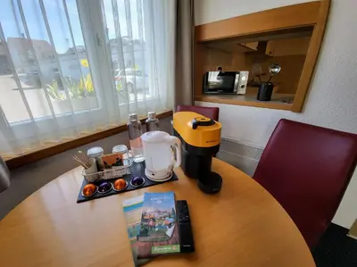 a table with a coffee maker and a book on it at Best Western Hotel Rebstock in Rorschacherberg