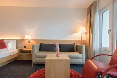a hotel room with a couch and a bed at Best Western Hotel Rebstock in Rorschacherberg