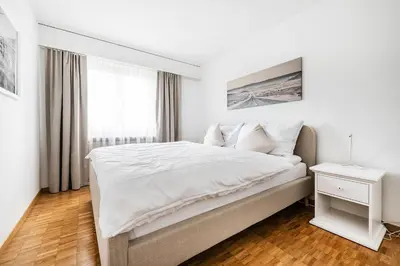 a white bedroom with a large bed and a window at SOHO 9 !Gratis Parken, Free Parking! in Kreuzlingen