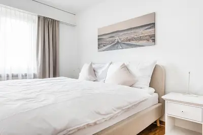 a white bedroom with a bed and a bridge at SOHO 9 !Gratis Parken, Free Parking! in Kreuzlingen