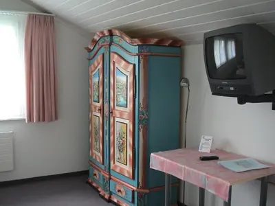 a large wooden cabinet with a tv in a room at Panorama Hotel Freudenberg in Appenzell