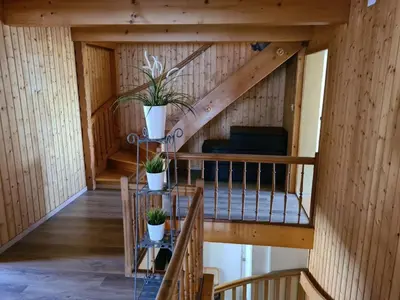 an attic room with stairs and potted plants at Backpacker Bären in Urnäsch