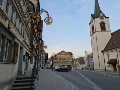 a city street with a building and a church at Backpacker Bären in Urnäsch