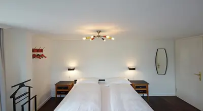 a bedroom with two beds and a ceiling fan at Alte Metzg - Boutique Pension in Appenzell