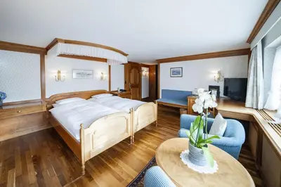 a bedroom with a bed and a desk and a window at Hotel Säntis in Appenzell
