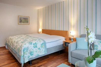 a hotel room with a bed and a chair at Hotel Löwen in Appenzell
