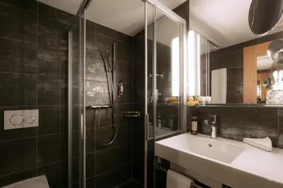a bathroom with a glass shower and a sink at Hotel Löwen in Appenzell