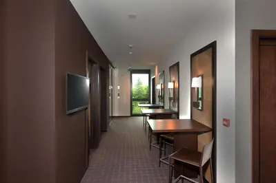 a hallway with tables and chairs and a television at b-smart motel Sevelen in Sevelen