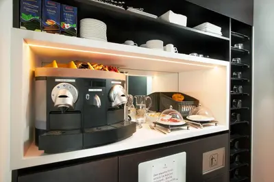 a kitchen with a coffee maker on a shelf at b-smart motel Sevelen in Sevelen