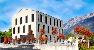 a white building with trees in front of a mountain at b-smart motel Sevelen in Sevelen