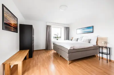 a bedroom with a bed and a wooden floor at SOHO 5A !Gratis Parken, Free Parking! in Kreuzlingen