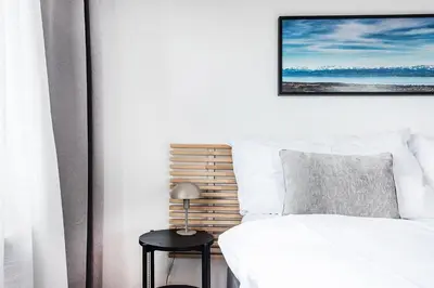 a bedroom with a white bed and a black stool at SOHO 5A !Gratis Parken, Free Parking! in Kreuzlingen