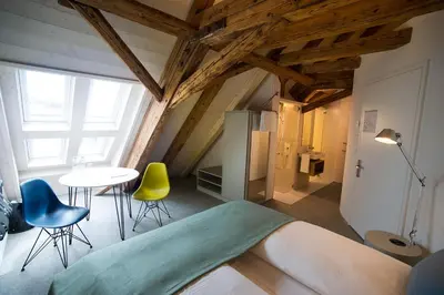 a room with a bed and a table and chairs at Gasthaus zum Trauben in Weinfelden