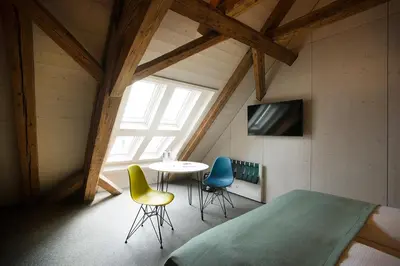 a room with a table and chairs in a attic at Gasthaus zum Trauben in Weinfelden