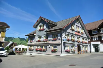 a building with flower boxes on the side of it at Gasthaus Gemsli in Nesslau