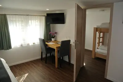 a small room with a table and chairs and a bed at Gasthaus Gemsli in Nesslau