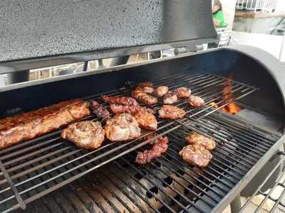 a bunch of meat and sausages cooking on a grill at Gasthaus Gemsli in Nesslau