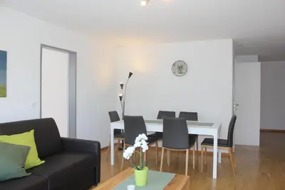 a living room with a dining room table and chairs at Herisau Apartments in Herisau