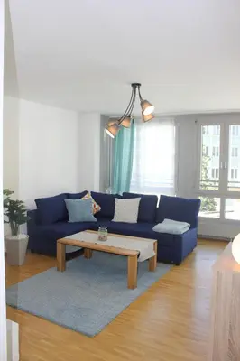 a living room with a blue couch and a coffee table at Herisau Apartments in Herisau