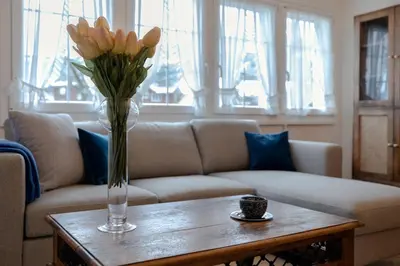 a vase of flowers on a table in a living room at Blattenheimat - im traditionellen Appenzeller Haus in Appenzell