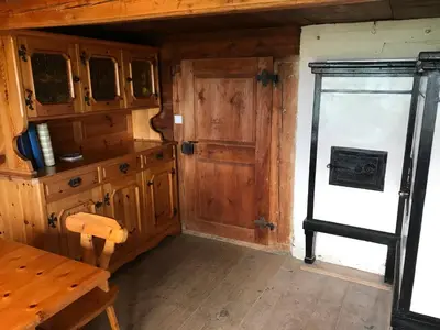 a kitchen with wooden cabinets and a door and a table at Alphütte Burst in Alt Sankt Johann