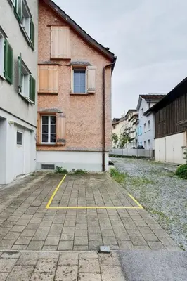 an empty parking lot in front of a building at Bright and modern apartment in the heart of Altstätten in Altstätten