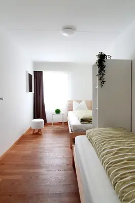 a bedroom with two beds and a window at Bright and modern apartment in the heart of Altstätten in Altstätten