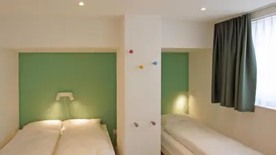 a bedroom with two beds and a window at Alte Metzg - Hostel in Appenzell