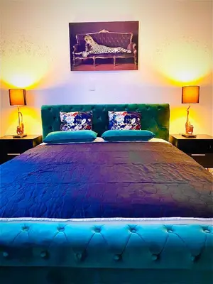 a blue bed in a bedroom with two lamps at City Center Premium Apartment - Buchs SG in Buchs