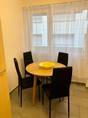 a dining room table with chairs and a yellow plate on it at City Center Premium Apartment - Buchs SG in Buchs