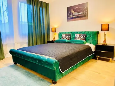 a bedroom with a green bed with a green headboard at City Center Premium Apartment - Buchs SG in Buchs