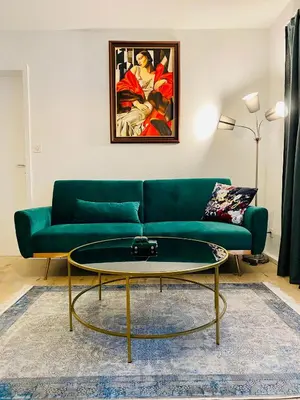 a living room with a green couch and a table at City Center Premium Apartment - Buchs SG in Buchs