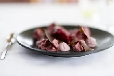 a plate of food with meat on a table at Vegan Health Hotel Sonnenberg in Schwellbrunn