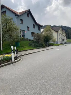 an empty street with a house and parking meters at BNB Claudia in Appenzell