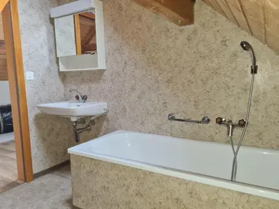 a bathroom with a bath tub and a sink at Alpen-Paradies Edelweiss in Urnäsch