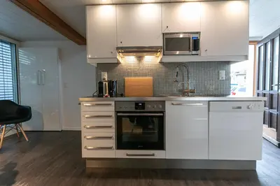 a kitchen with white cabinets and a microwave at INN JOY Apartments - Sankt Gallen West in St. Gallen